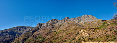 Buy stock photo Twelve Apostles at Table Mountain in Cape Town against a blue sky background from below. Breathtaking view of plants and shrubs growing around a majestic rocky valley and scenic landmark in nature