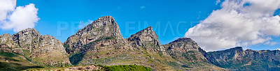 Buy stock photo Mountain landscape against a cloudy blue sky background with copy space. Rocky hills and cliffs on The twelve apostles in Cape Town, Western Cape. Beautiful travel destination and tourist attraction 