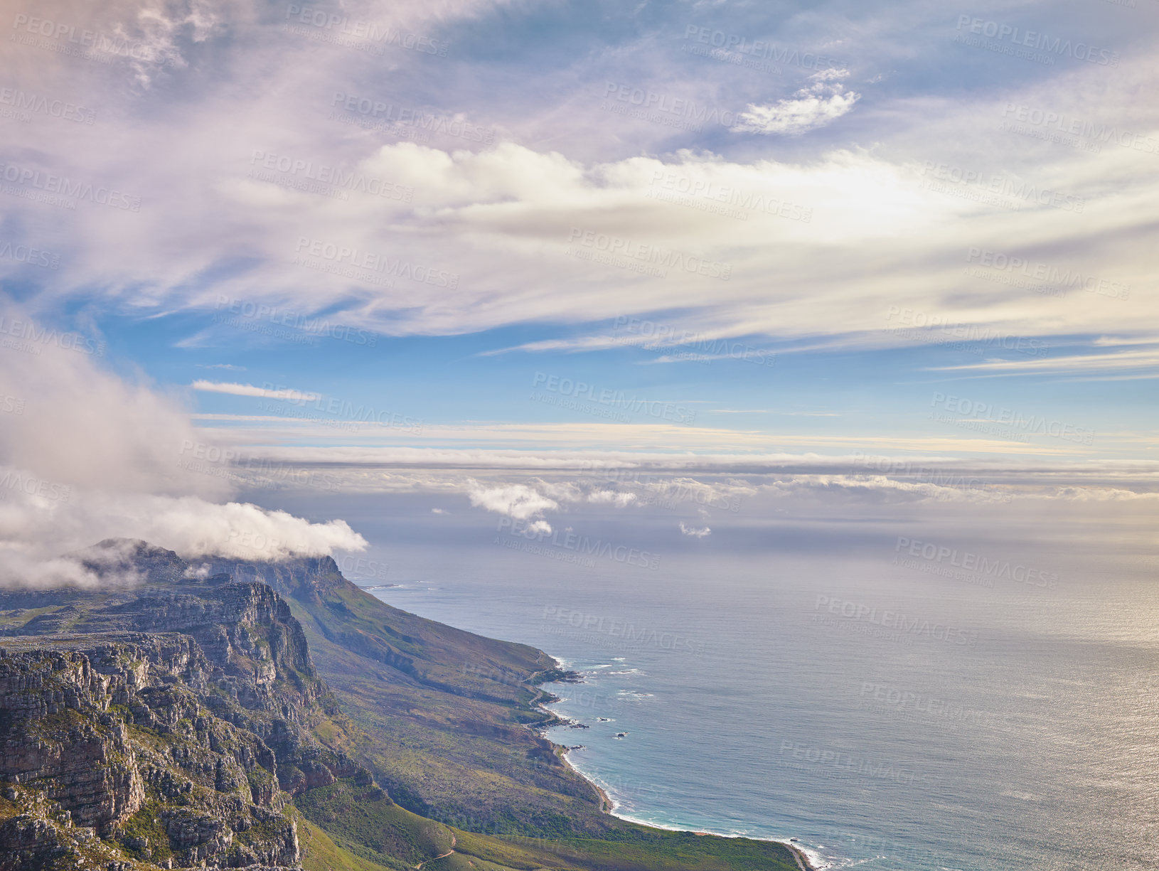 Buy stock photo Aerial view of a calm ocean and mountains with a blue cloudy sky background and copy space. Stunning nature landscape of the sea and horizon from Table Mountain tourism destination in Cape Town