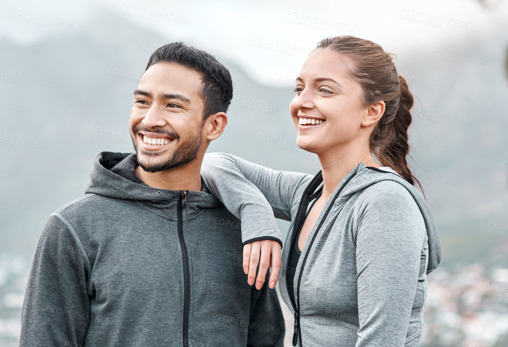 Buy stock photo Shot of a sporty young man and woman exercising outdoors