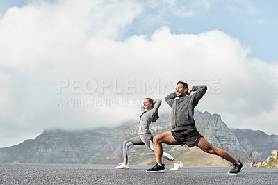 Buy stock photo Shot of a sporty young man and woman stretching their legs while exercising outdoors