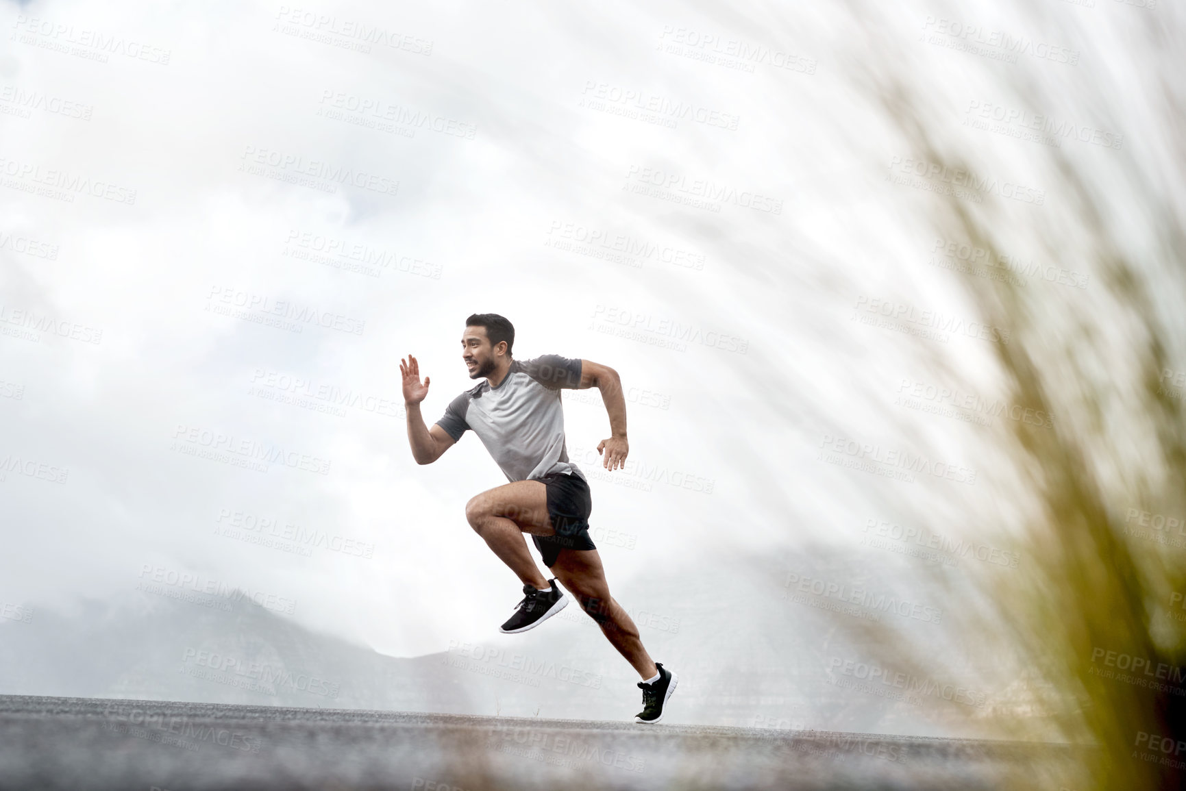 Buy stock photo Shot of a sporty young man running outdoors