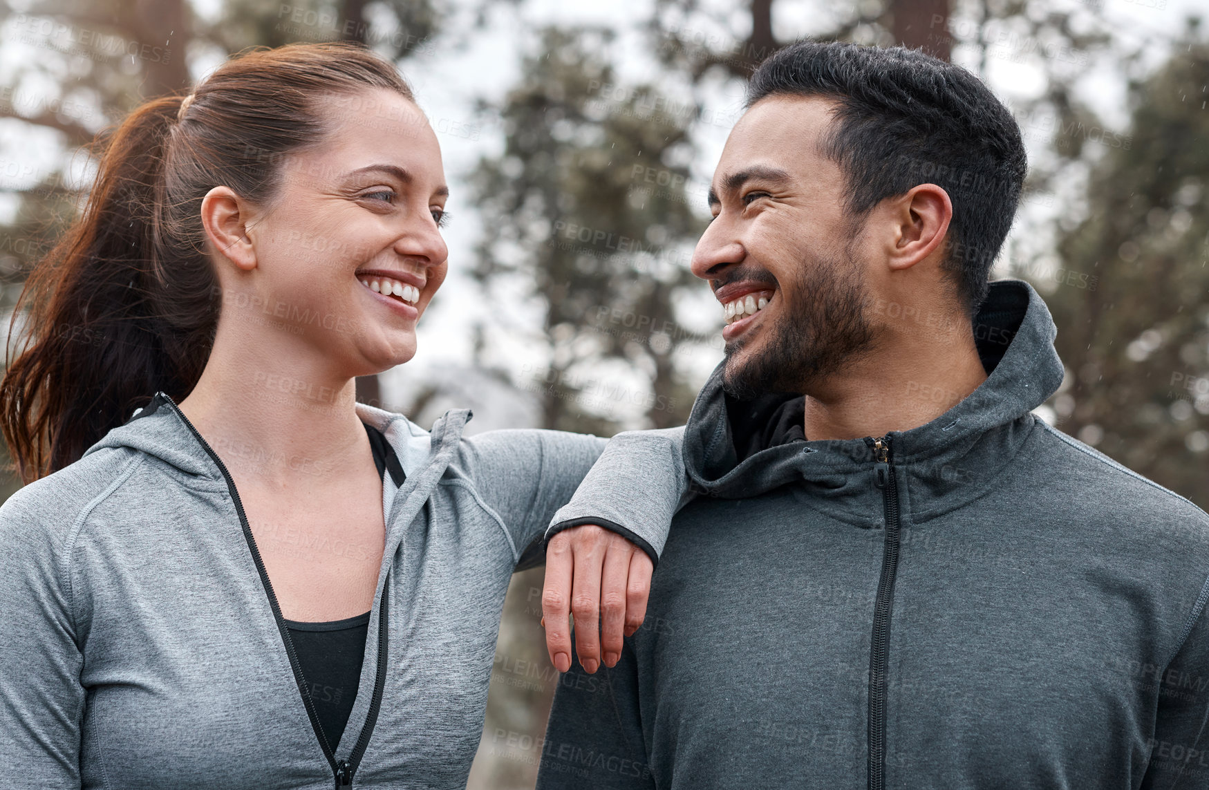 Buy stock photo Shot of a sporty young man and woman exercising outdoors