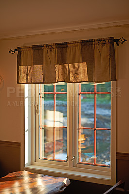 Buy stock photo Big kitchen window with sunlight shining through on a wooden table. Rustic home with an outside view that lights up the room in summer. Cozy corner in a house to sit and enjoy family time and meals