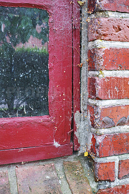 Buy stock photo Closeup of abandoned red window covered in spiderwebs from neglect, poverty and economic crisis. Empty, old and dirty residential brick building or home in village with broken frame on the windowsill