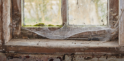 Buy stock photo Abandoned, dirty and dusty window covered in spiderwebs in empty house from poverty and economic crisis. Old, damaged and weathered wooden windowsill and wood frame rotting from dampness and neglect 