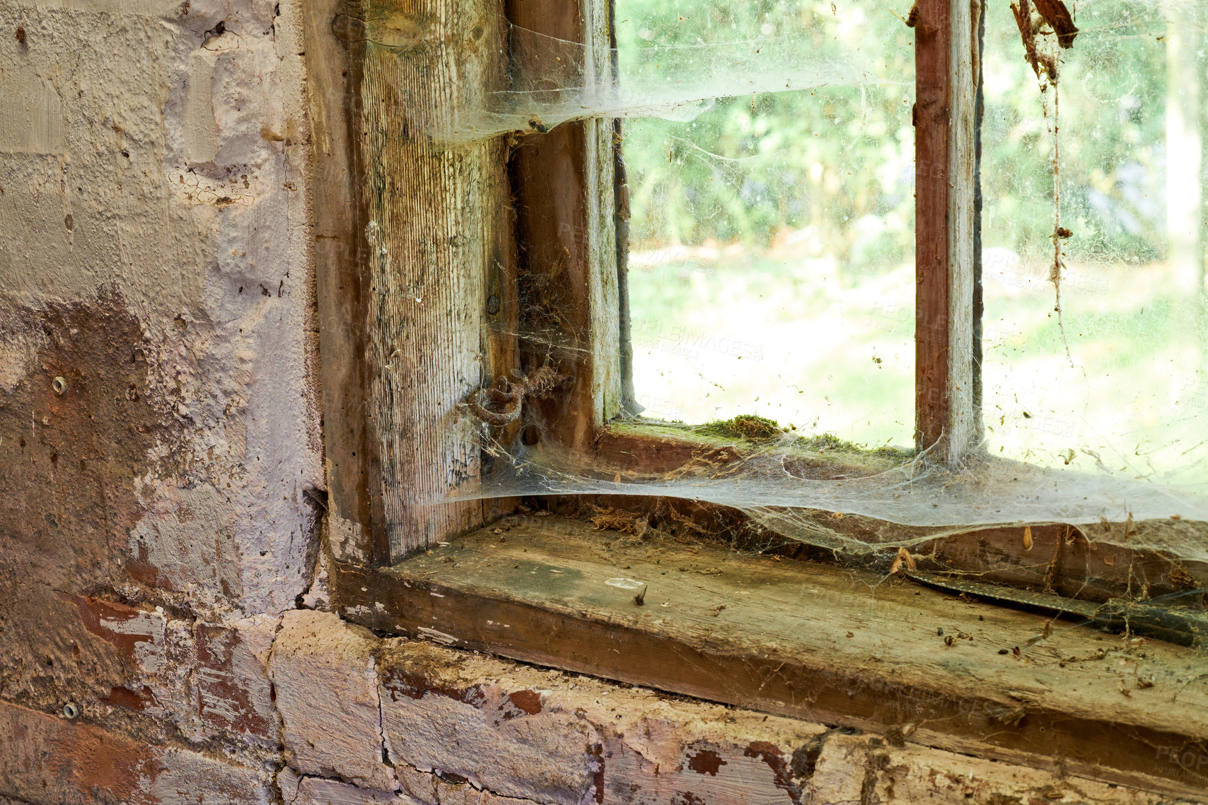 Buy stock photo Interior view of an ancient house in need of TLC. An old window with dust and spiderwebs in an abandoned home inside. Architecture details of a windowsill frame with damaged rustic textures. 