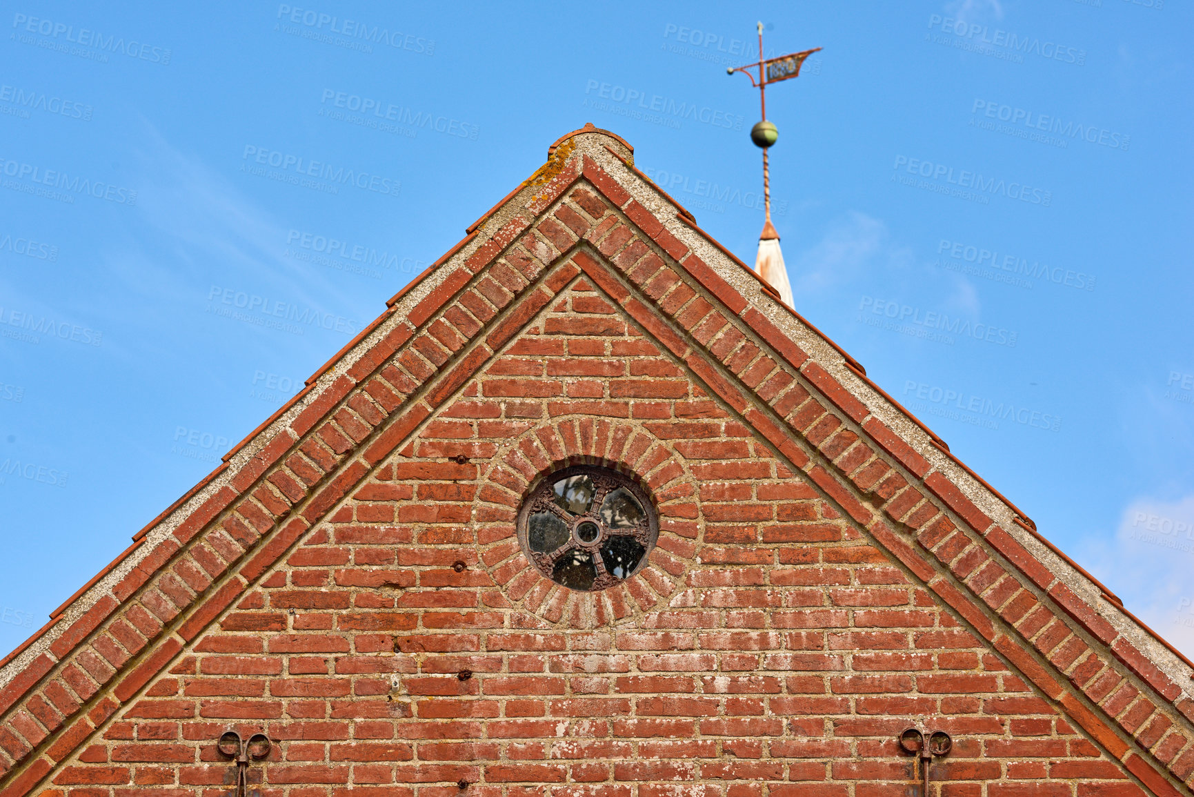 Buy stock photo View of a round window on an old red brick wall of a house or home. Glass with metal frame on historic church building. Architecture design and details on a city structure outside with copy space