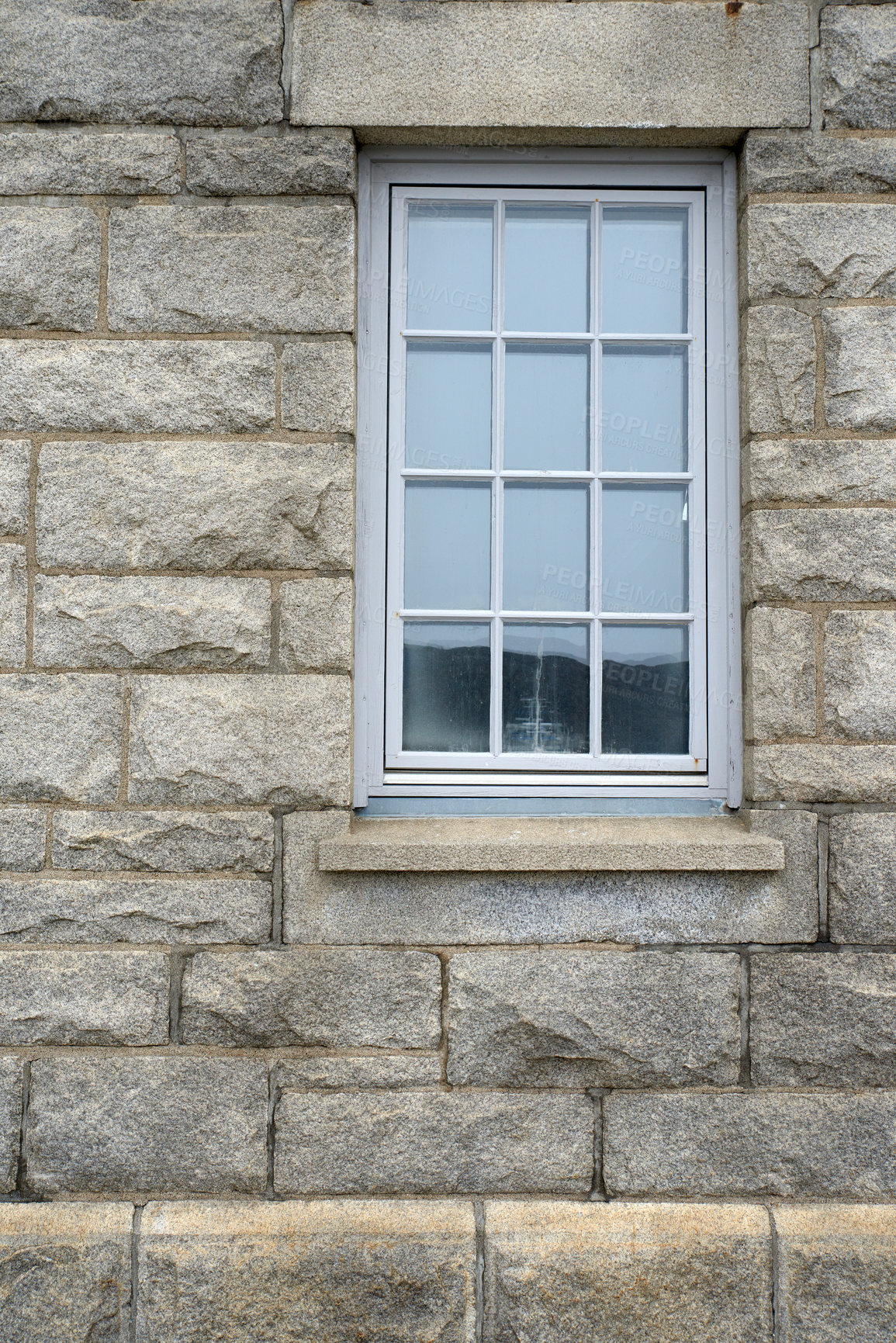 Buy stock photo Shiny window and architecture of a grey brick wall. Exterior texture details of an old rustic residential building or private home with modern wooden windows and windowsill in a town or village 