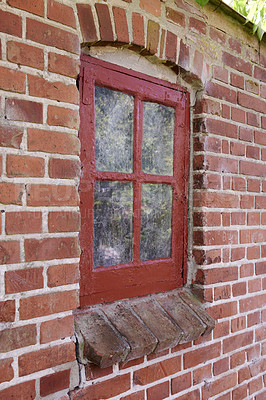 Buy stock photo Old dirty window in a red brick house or home. Decaying casement with redwood frame on a historic building with clumpy paint texture. Exterior details of a windowsill in a traditional town or village