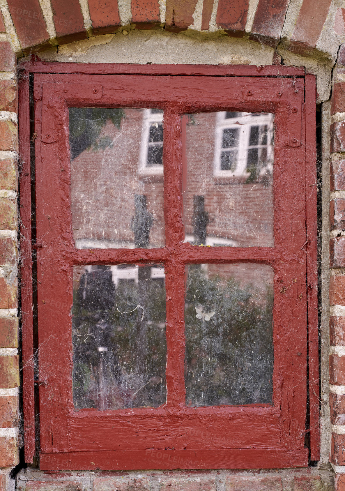 Buy stock photo Closeup of an old dirty window in a red brick home. Zoom in on casement with red wood frame on a historic building with bumpy paint texture. Macro exterior details of windowsill in a traditional town