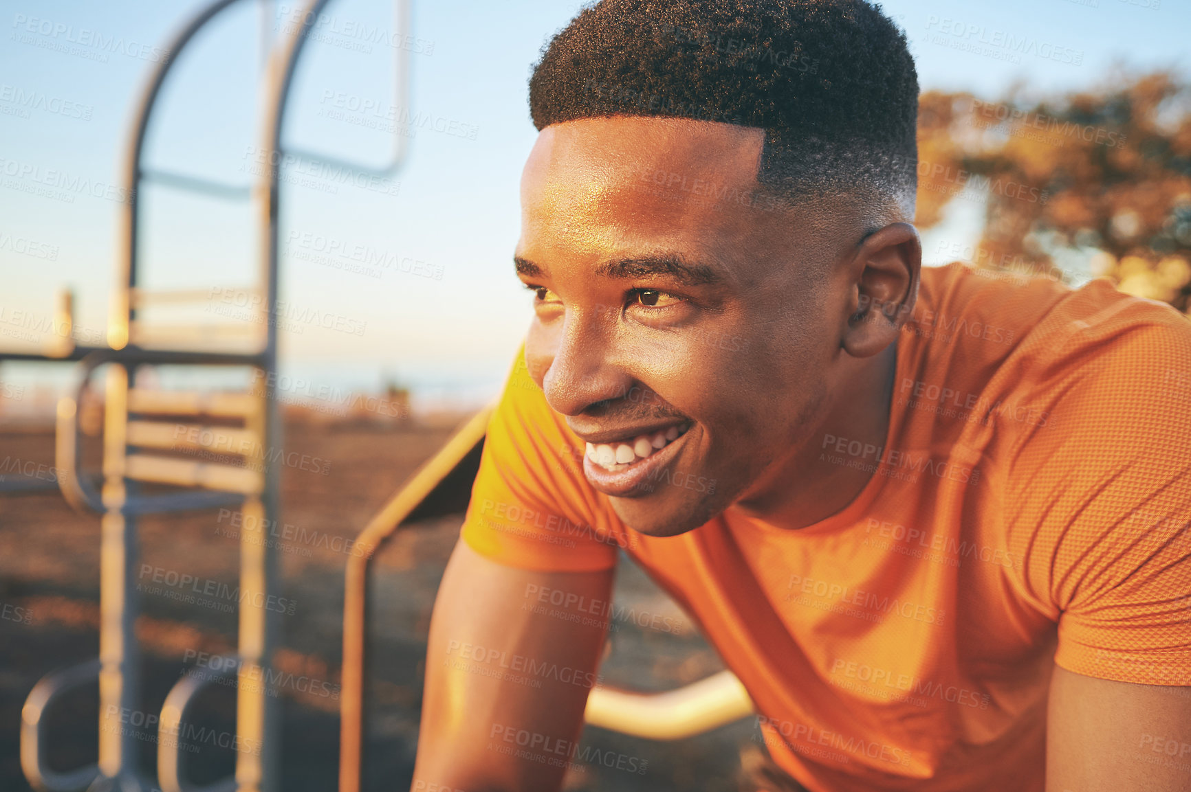 Buy stock photo Cropped shot of a young man looking happy while out at the park for a workout