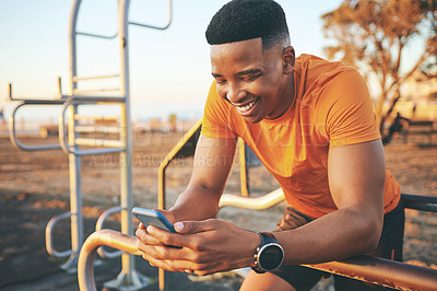 Buy stock photo Shot of a man checking his cellphone while out for a workout