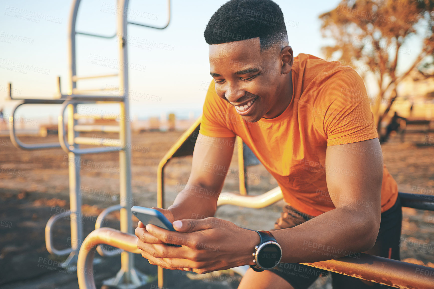 Buy stock photo Shot of a man checking his cellphone while out for a workout