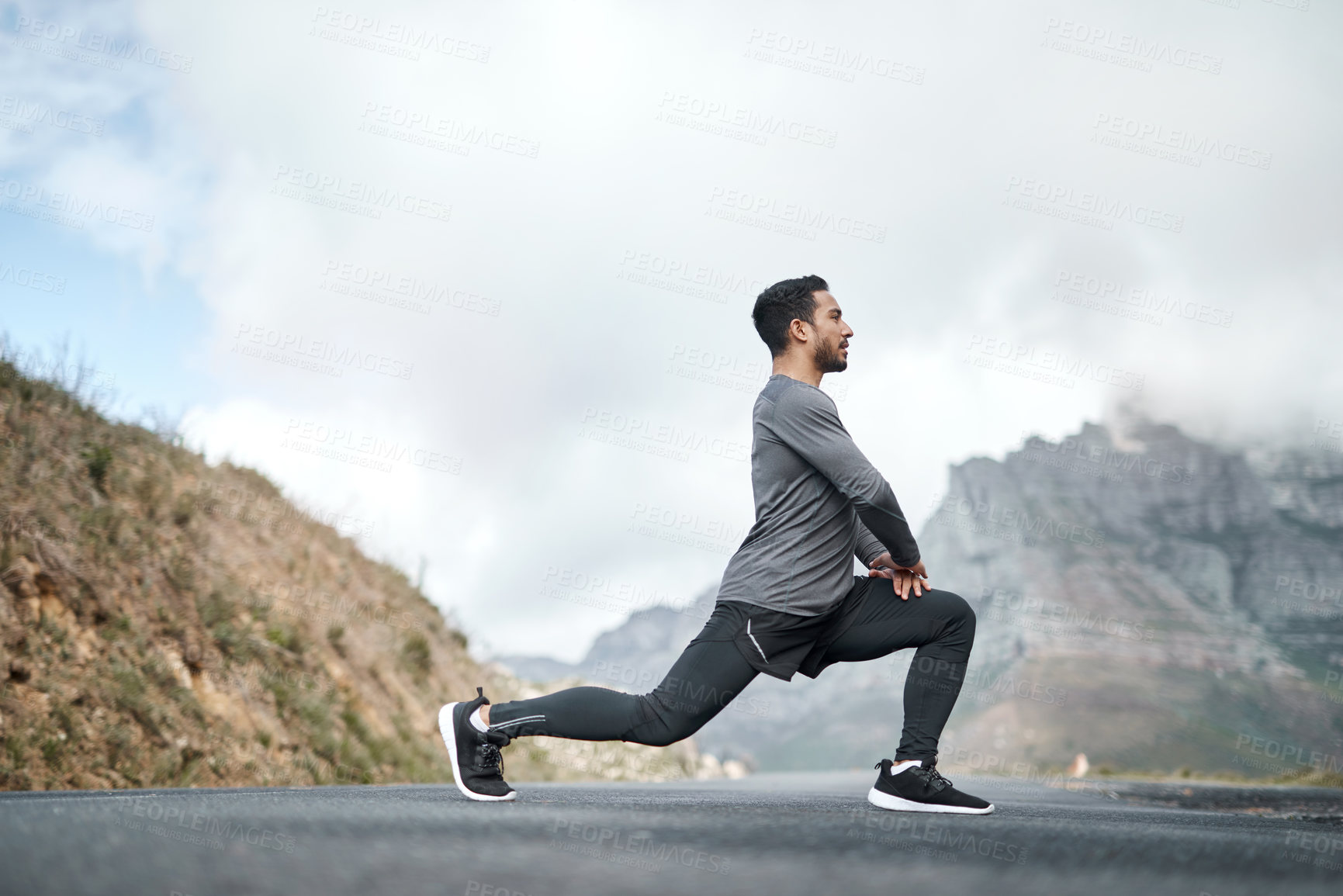 Buy stock photo Full length shot of a handsome young man stretching before exercising outdoors alone