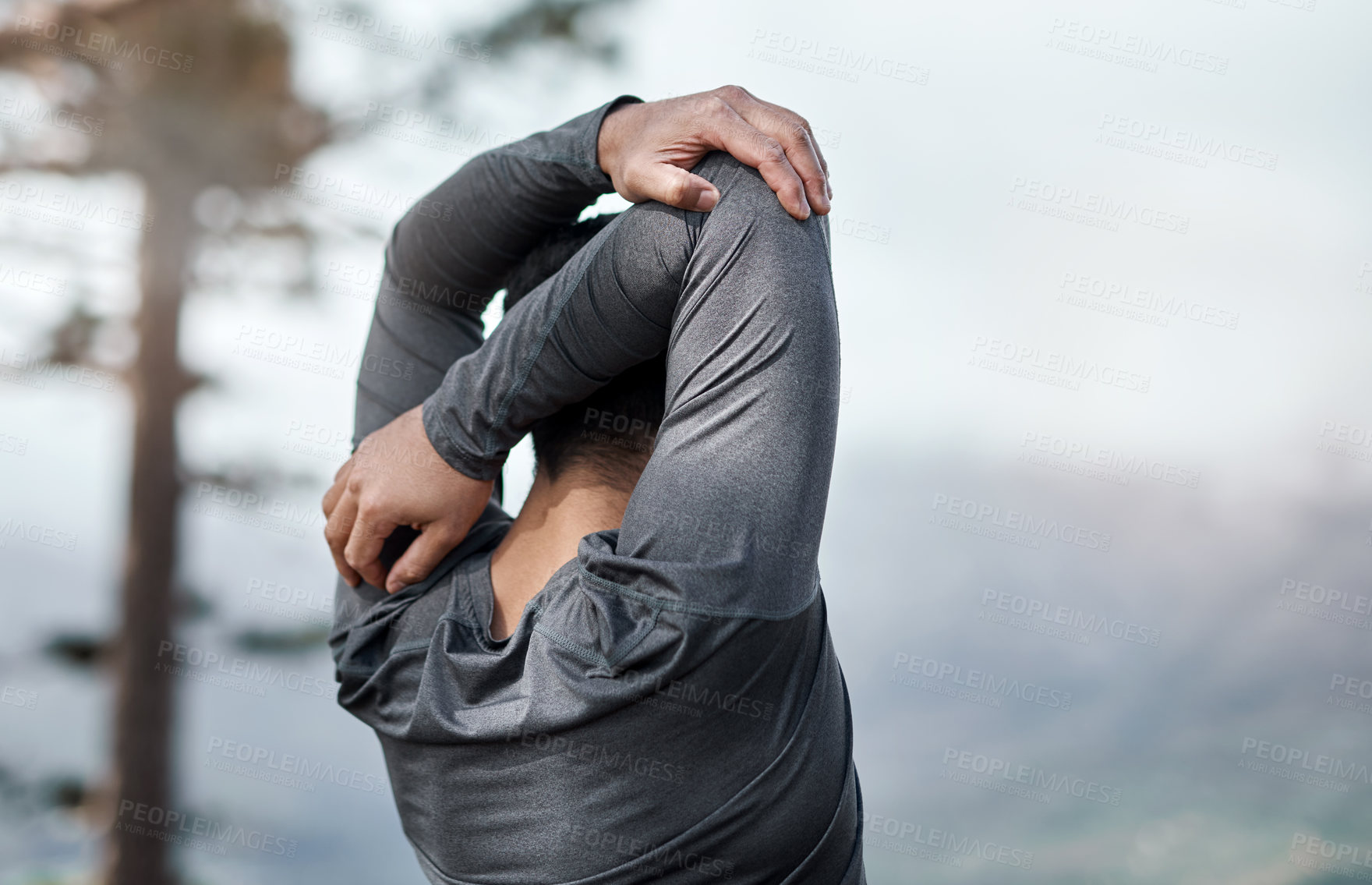 Buy stock photo Cropped shot of an unrecognizable man stretching before exercising outdoors alone