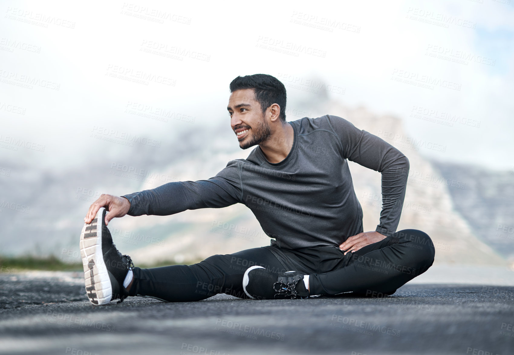 Buy stock photo Full length shot of a handsome young man stretching before exercising outdoors alone