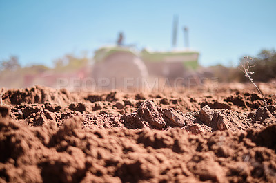 Buy stock photo Shot of a tractor ploughing a field on a farm