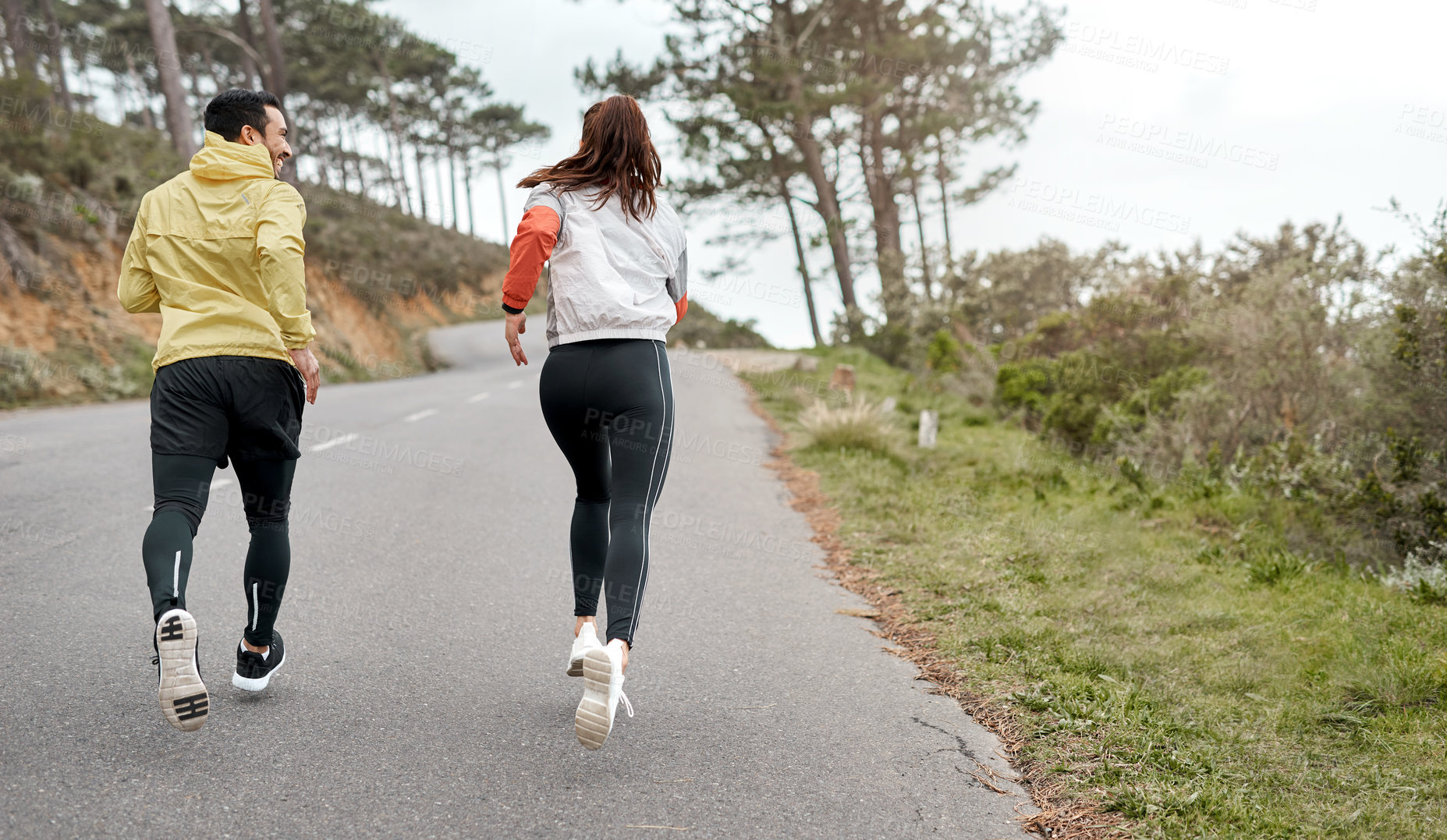 Buy stock photo Full length shot of two young athletes bonding together during a run outdoors