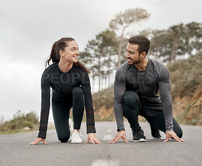 Buy stock photo Full length shot of two young athletes crouched down in a starters position before exercising outside