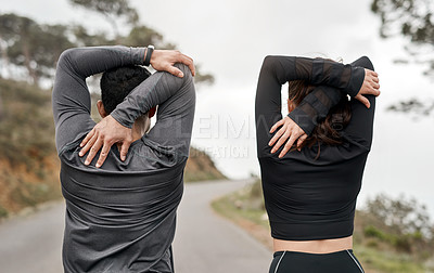 Buy stock photo Cropped shot of two unrecognizable athletes stretching before exercising outdoors together