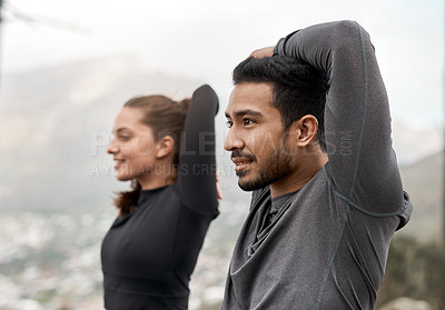 Buy stock photo Cropped shot of two young athletes stretching before exercising outdoors together