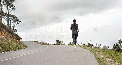 Buy stock photo Full length shot of an unrecognizable woman jogging alone outdoors