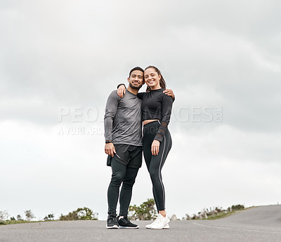 Buy stock photo Full length portrait of two young athletes standing with their arms around each other after their morning run outdoors