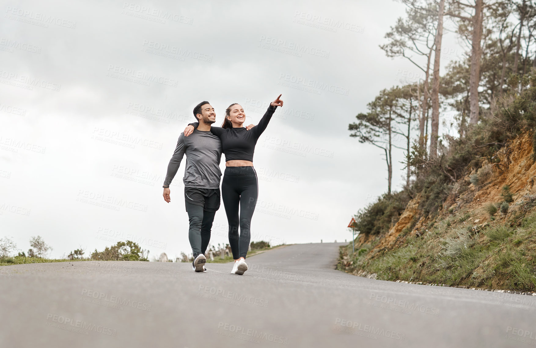 Buy stock photo Full length shot of two young athletes walking with their arms around each other after a run outdoors