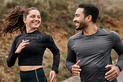 Buy stock photo Cropped shot of two young athletes bonding together during a run outdoors