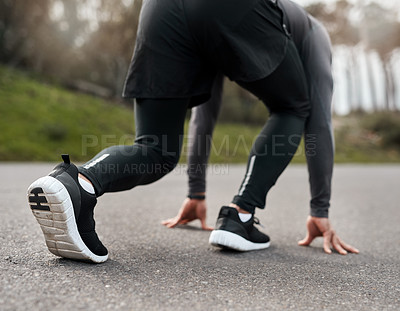 Buy stock photo Cropped shot of an unrecognizable man crouched down in a starters position before exercising outside