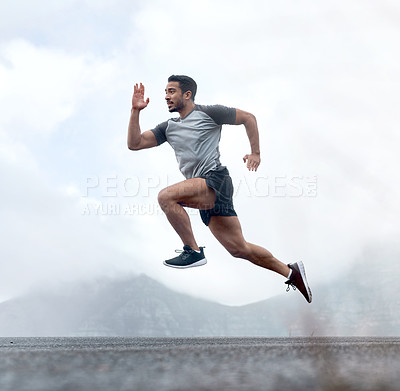 Buy stock photo Full length shot of a handsome young man jumping during a workout outdoors