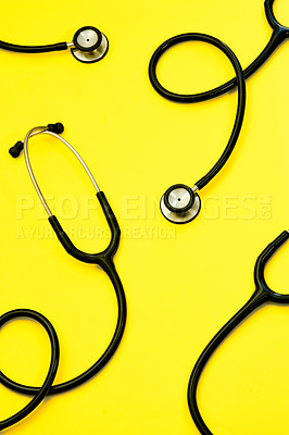 Buy stock photo Studio shot of stethoscopes against a bright yellow background