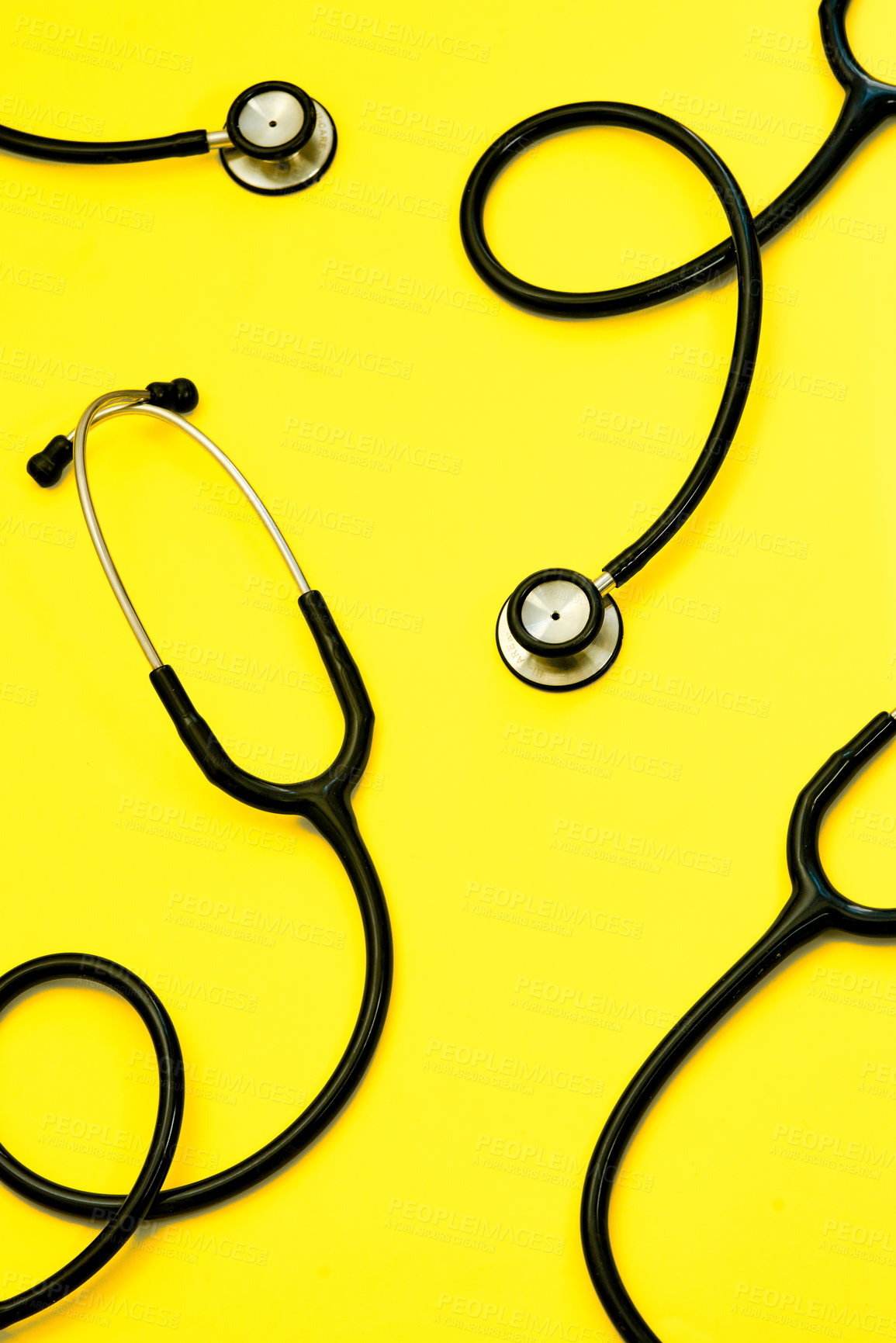 Buy stock photo Studio shot of stethoscopes against a bright yellow background