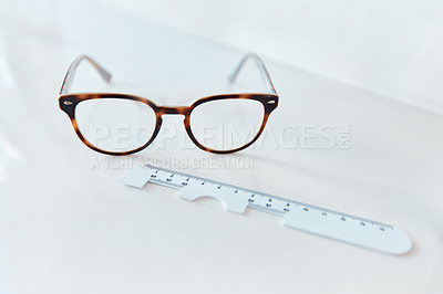 Buy stock photo Shot of a pair of glasses and a pd ruler in an optometrist’s office