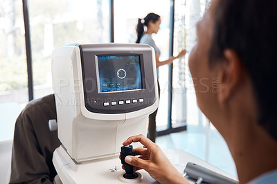Buy stock photo Shot of an optometrist using an autorefractor during an eye exam