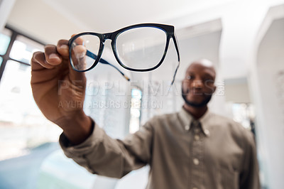Buy stock photo Shot of a young woman buying a new pair of glasses at an optometrist store
