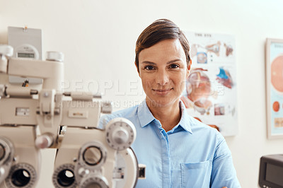 Buy stock photo Portrait of a confident woman using an optical refractor in an optometrist’s office