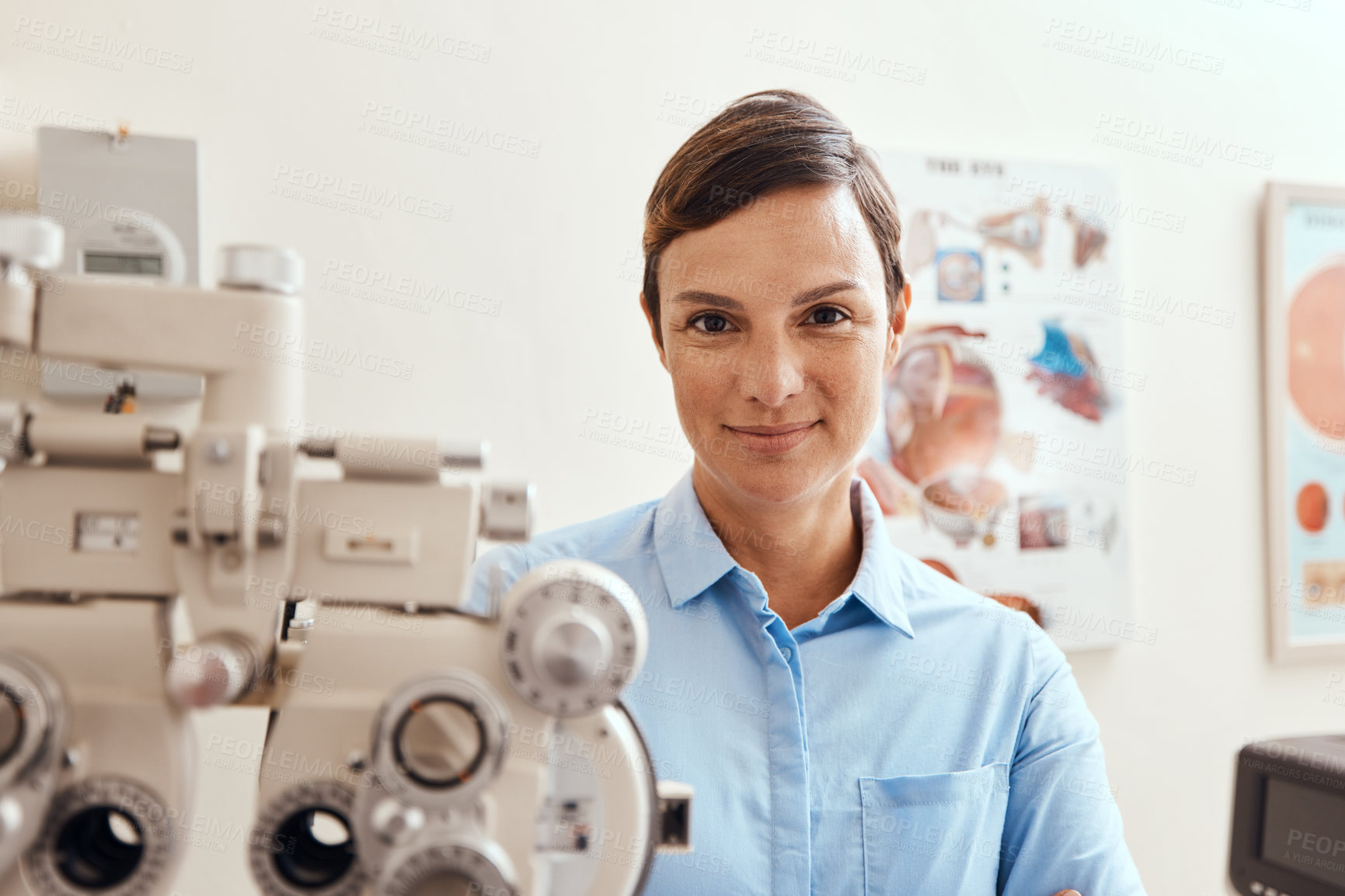 Buy stock photo Portrait of a confident woman using an optical refractor in an optometrist’s office