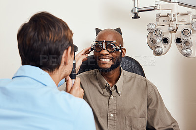 Buy stock photo Optical exam, optician or eye doctor at work testing vision or sight of patient at optometrist. Happy, smiling young man checking his eyes for glasses or treatment at an ophthalmologist in a clinic.