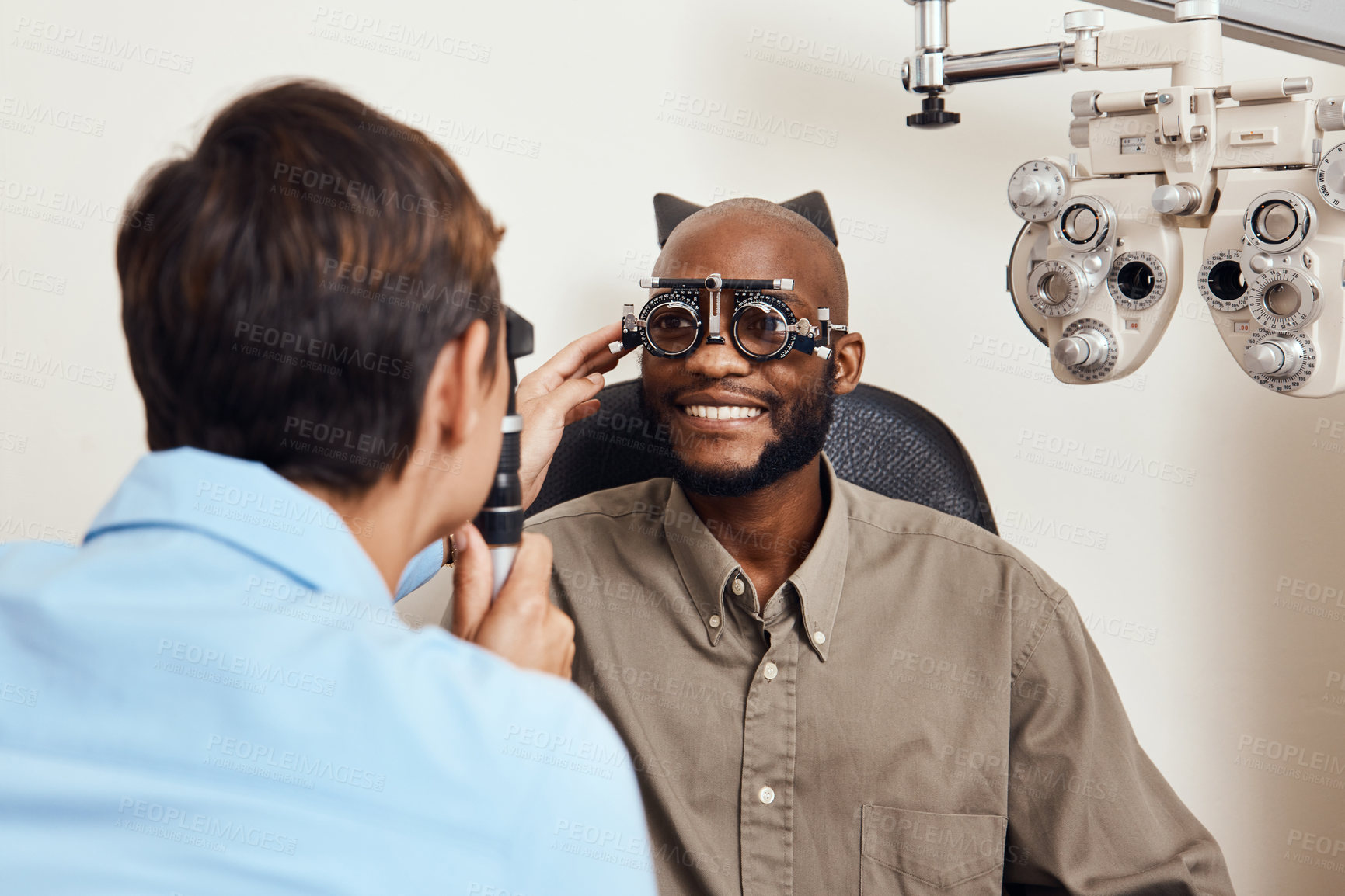 Buy stock photo Optical exam, optician or eye doctor at work testing vision or sight of patient at optometrist. Happy, smiling young man checking his eyes for glasses or treatment at an ophthalmologist in a clinic.