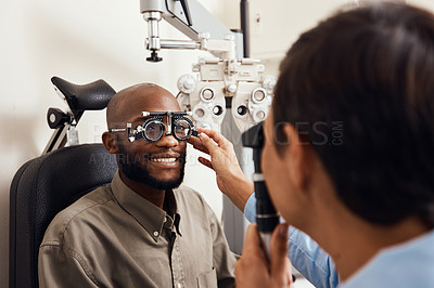 Buy stock photo Shot of an young man getting new glasses fitted by an optometrist