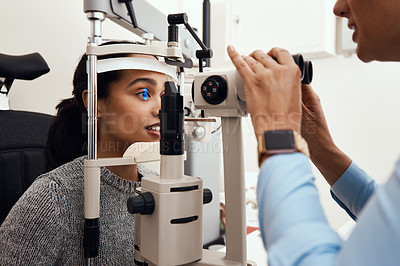 Buy stock photo Eye test, exam or screening with an ophthalmoscope and an optometrist or optician in the optometry industry. Young woman getting her eyes tested for prescription glasses or contact lenses for vision
