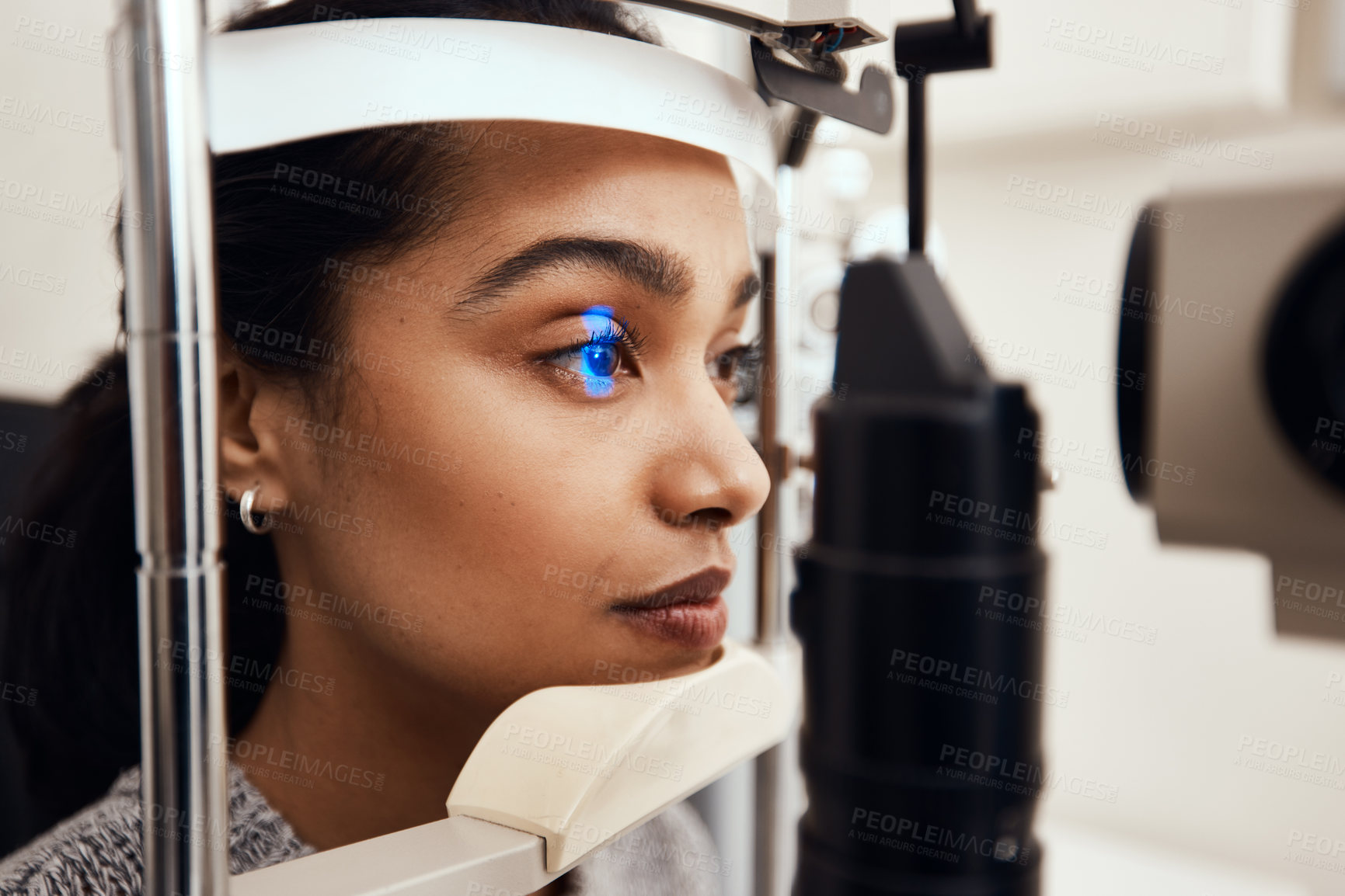 Buy stock photo Shot of a young woman getting her eye’s examined with a slit lamp