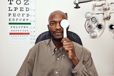 Buy stock photo Shot of a young man covering his eye with an occluder during an  eye exam