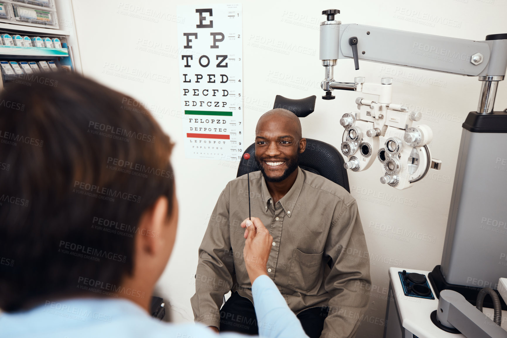 Buy stock photo Shot of a young man having an eye test conducted by an optometrist