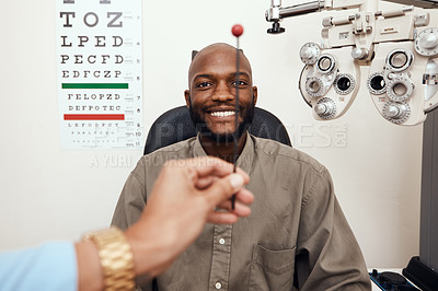 Buy stock photo Black man having his eyes tested at an optometrist. Smiling African American male consulting with an opthamologist, having a vision and eye care checkup. Guy testing for glaucoma or myopia 