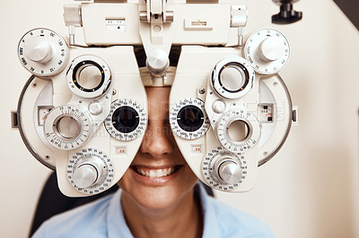 Buy stock photo Shot of a young woman getting her eye’s examined with an optical refractor