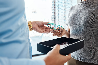 Buy stock photo Vision, sight and treatment by an optometrist giving a woman a pair of glasses. Closeup of a female buying spectacles to help with blurry vision. Lady with bad or weak eyesight getting eyeglasses 