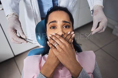 Buy stock photo Shot of a young woman looking scared while having dental work done on her teeth